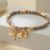 Pretty Gold Tone Stretch Bracelet with Light Purple Beads and Dragonfly Charm